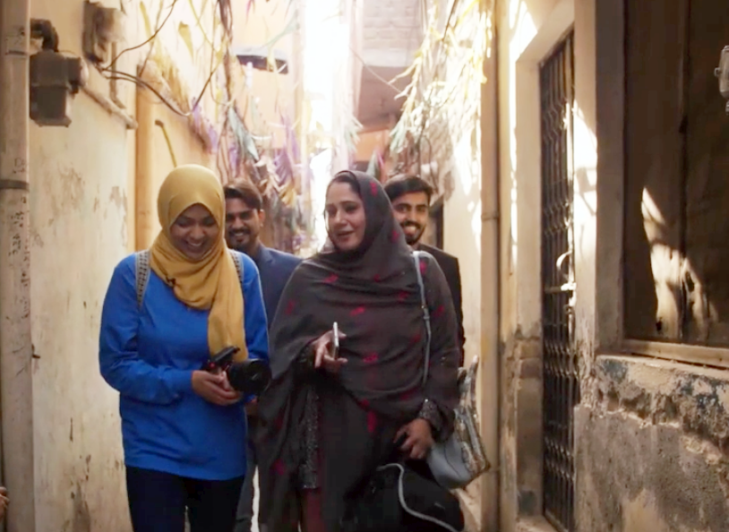 Yusra and three others walking down an narrow street
