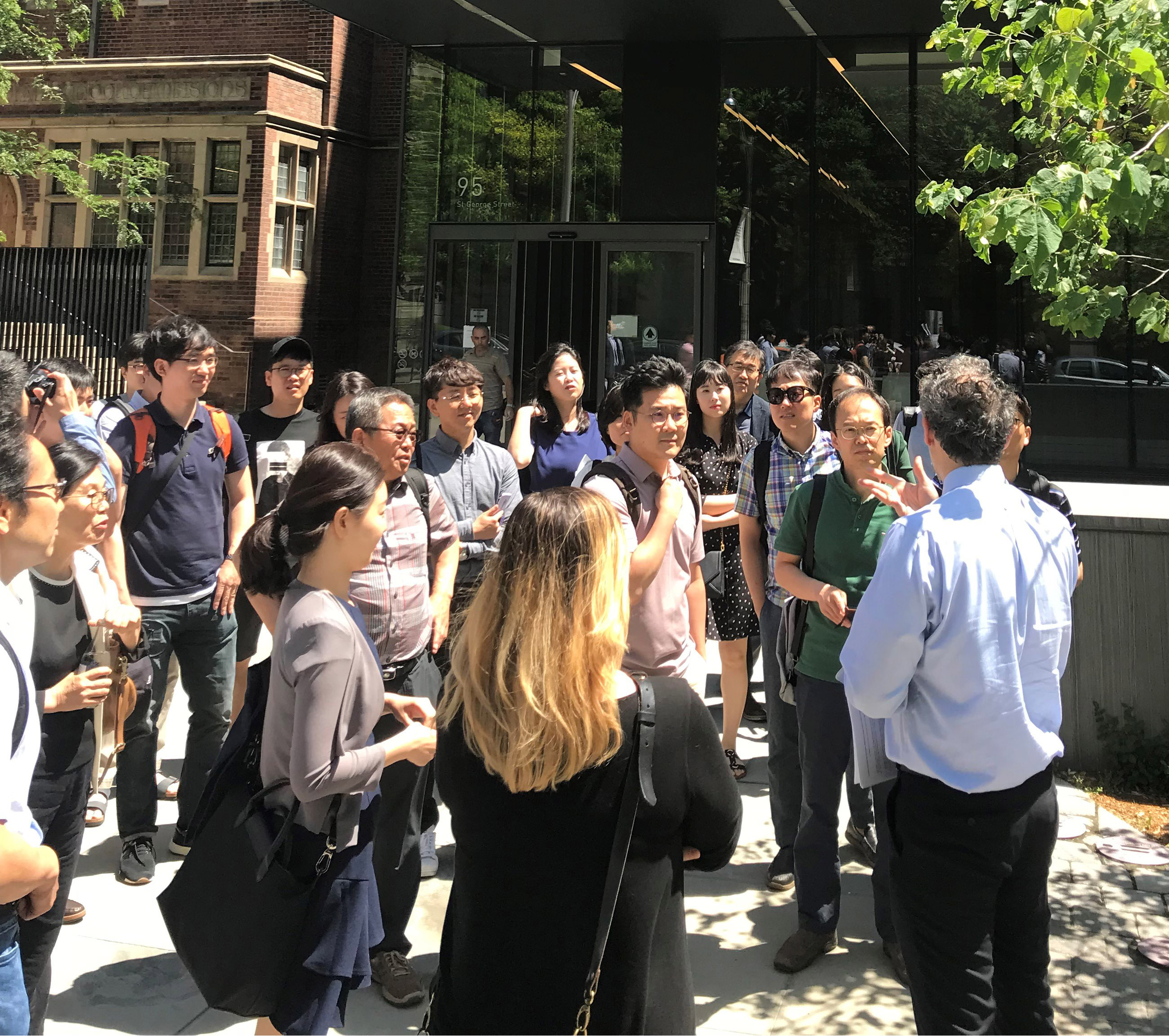 Rafael Gomez speaks to a group in front of the Rotman building